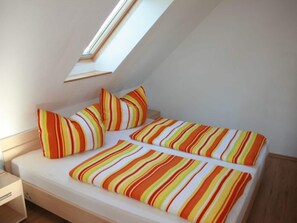 A small, single-bed room with a sloped ceiling and a skylight. - Kinderparadies - Ferienwohnung mit Garten (Blowatz)