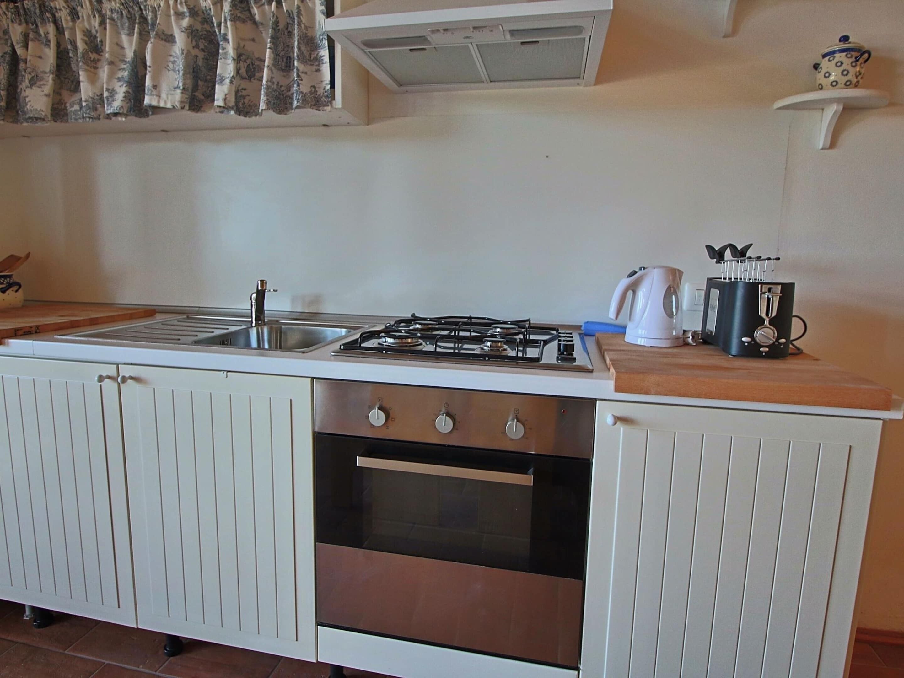 A kitchen with a gas stove, oven, and sink.