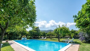 A rectangular swimming pool with a tiled edge, surrounded by a brick patio. - Holiday Home in Stilo With Pool & Views (Stilo)