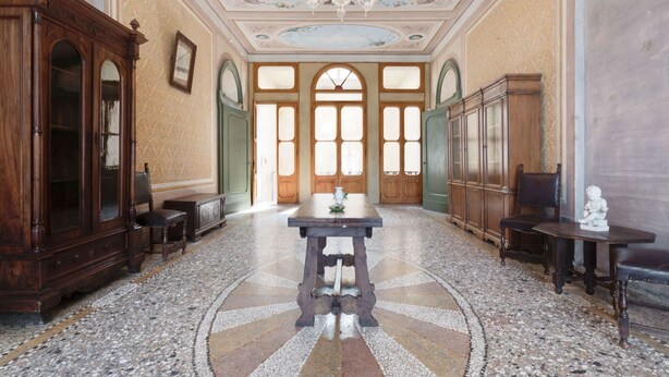 A spacious room with a large wooden cabinet, a table with a vase, and a statue on a small table. - Castle in Romano D'ezzelino With Garden (Romano d'Ezzelino)
