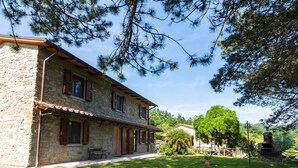 A stone building with a tiled roof, wooden shutters, and a bench outside. - Belvilla by OYO Gallorimpi (Dicomano)