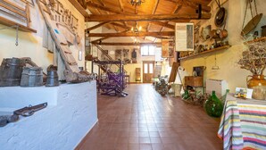A rustic interior with exposed wooden beams, a staircase, and various historical artifacts. - Holiday Home in Guardavalle Near Beaches (Stilo)