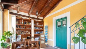 A cozy reading nook with wooden bookshelves, a table, chairs, and a green door. - Holiday Home in Guardavalle Near Beaches (Stilo)