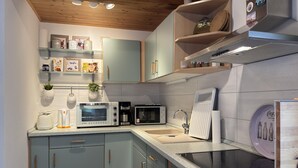 A modern kitchen with a built-in oven, microwave, coffee maker, and a sink.