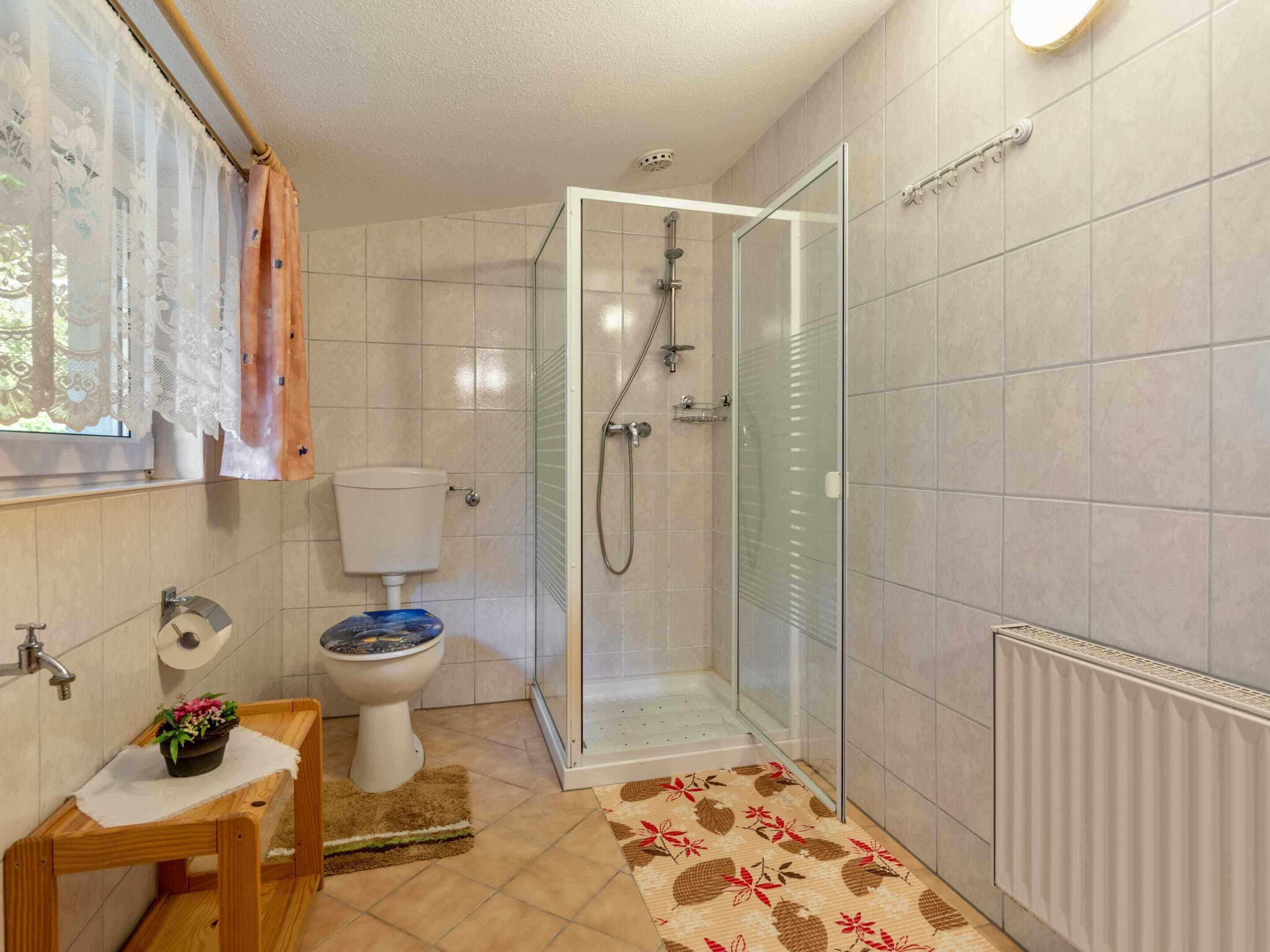 A bathroom with a toilet, shower, and sink.
