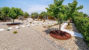 A landscaped garden with pathways, trees, and a bench. - Modern Home in Quiet Pristeg (Benkovac)