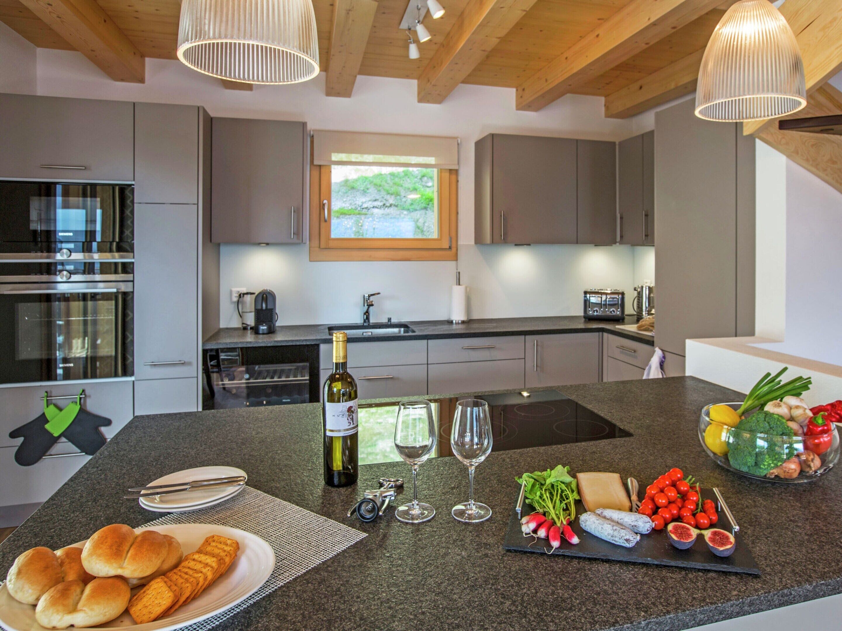 A modern kitchen with a central island, built-in appliances, and a view of the outdoors.