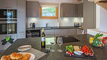A modern kitchen with a central island, built-in appliances, and a view of the outdoors.