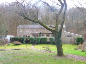 A stone house with a garden, a staircase leading to the entrance, and a tree in the foreground. - Home in Comblain-au-pont (Comblain-au-Pont)