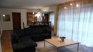 A living room with a sectional sofa, a coffee table, and a dining area in the background. - Home in Comblain-au-pont (Comblain-au-Pont)