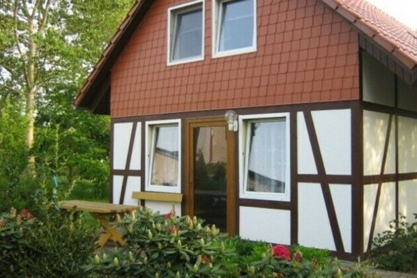 A two-story house with a brown tiled roof and white-framed windows. - Ferienhaus mit Sauna und Whirlpool (Boergerende-Rethwisch)