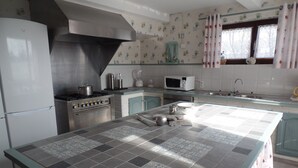 A kitchen with a large island, a stove, a microwave, and a sink. - Farmhouse in Aublain With Terrace (Couvin)