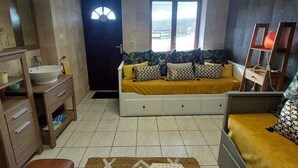 A room with a bed, a sofa, a small table, a mirror, and a window with a view. - Farmhouse in Aublain With Terrace (Couvin)
