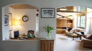 A cozy living room with a dining area, wooden cabinets, a mirror, and a framed picture on the wall. - Apartment Belvedere (Lauterbrunnen)