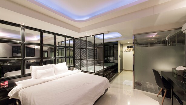 A modern hotel room with a large bed, a glass partition wall, and a separate shower area. - Aria Motel (Busan)