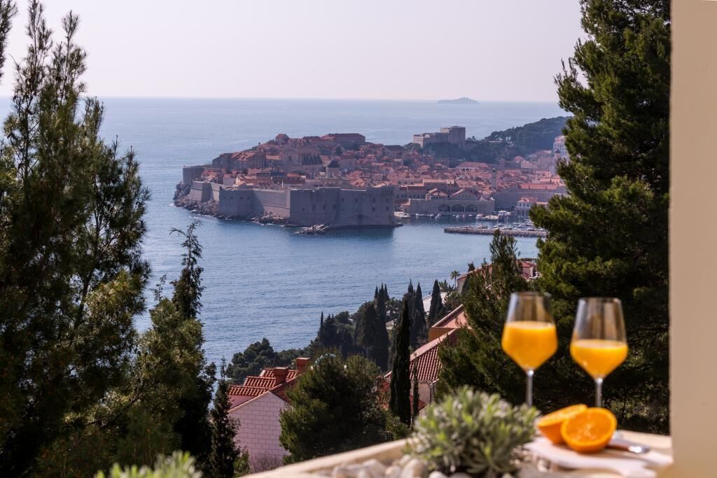 A coastal cityscape with a fortified historic center, overlooking the sea.
