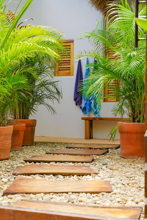 Caminho que leva a um banco, com vasos de plantas de ambos os lados.