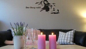 Ett bord med två rosa ljus, en krukväxt och vinglas.