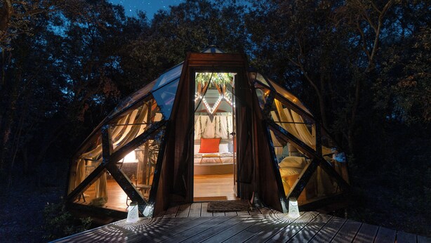 A geodesic dome structure with a bed and a small table, surrounded by trees and a starry night sky. - Le Mas Cabanids (Maureillas-Las-Illas)