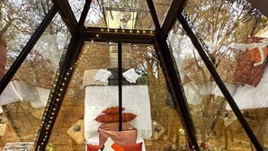 A cozy, triangular room with a bed, pillows, and a small table. - Le Mas Cabanids (Maureillas-Las-Illas)
