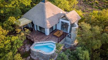 Relax in a serene outdoor space with a pool and deck, surrounded by lush forest.