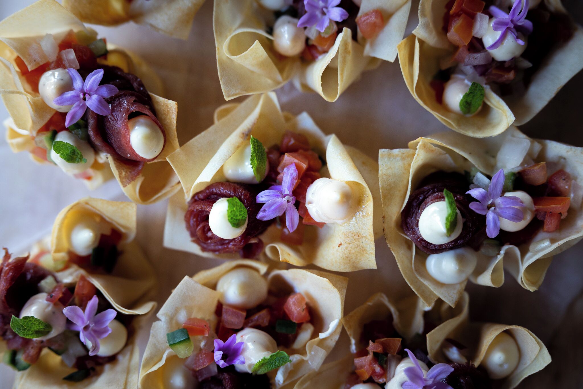 A close-up of food items in paper cups with various toppings.