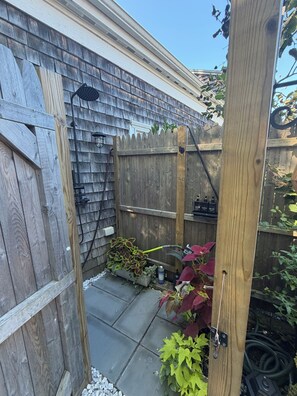 A wooden fence with a gate, a hose, and potted plants. - Modern 1 bed/Studio - Steps from the Center of Town (Provincetown)