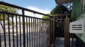 A gated entrance with a metal fence, a bench, and a tiled wall. - TC1203 Janela para o Mar (Rio de Janeiro)