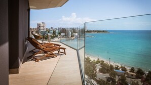 A balcony with wooden chairs overlooking a beach and cityscape. - Modern stunning views sea front SEA WATER APARTMENT (Alicante)