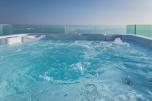 Ein Whirlpool mit klarem Wasser, umgeben von Glasgeländern.