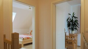 A bedroom with a bed, a desk, and a potted plant. - Modernes Apartment in Kuehlungsborn mit Garten (Kuehlungsborn)