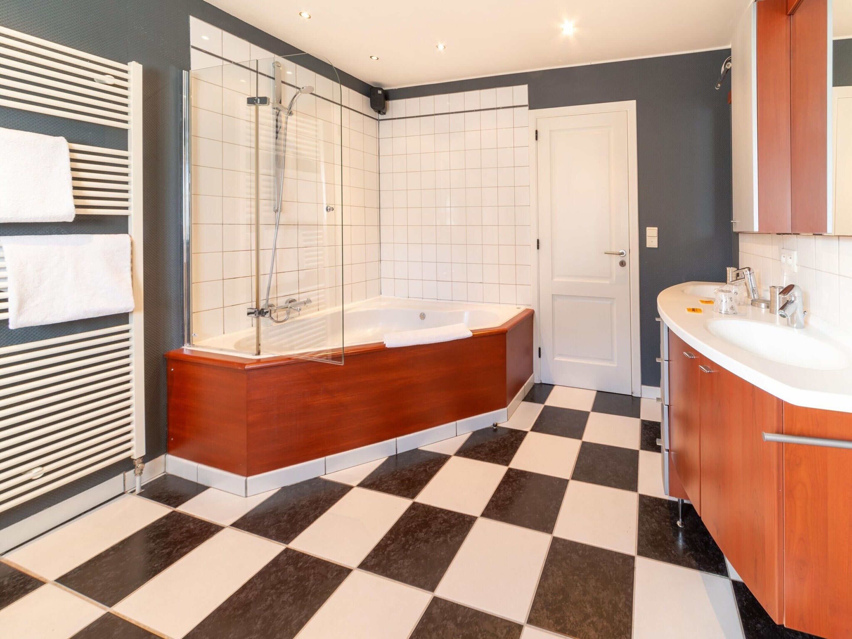 A modern bathroom with a freestanding bathtub, a glass-enclosed shower, and a large vanity with a sink.