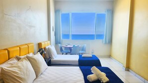 A hotel room with two beds, a dining area, and a view of the sea. - TC801 Charmoso Studio na Areia de Copacabana (Rio de Janeiro)