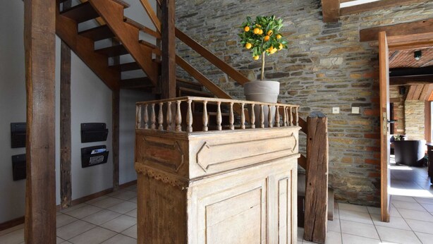 A staircase with wooden railings, a stone wall, and a potted plant with yellow flowers. - Alluring Farmhouse in Lavacherie with Hot Tub (Sainte-Ode)
