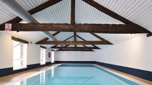 An indoor swimming pool with a wooden ceiling and white walls. - Alluring Farmhouse in Lavacherie with Hot Tub (Sainte-Ode)