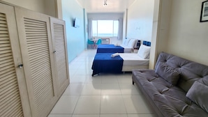 A hotel room with two beds, a sofa, a TV, and a dining area with chairs and a table. - TC802 Vistão Praia de Copa (Rio de Janeiro)