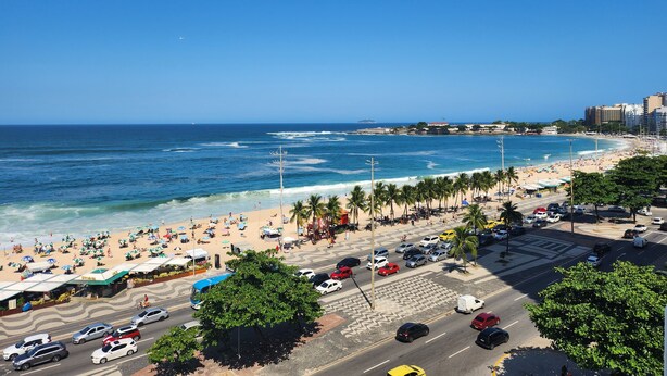 A beachside view with a road, cars, and beachgoers. - TC802 Vistão Praia de Copa (Rio de Janeiro)