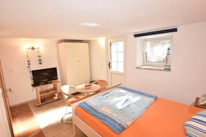 Cozy room with a single bed, TV, and wardrobe, offering a comfortable space to unwind.