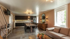 Una cocina moderna con comedor, sofá y televisor.
