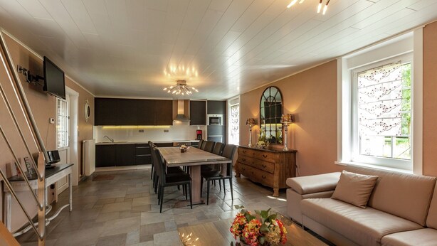 A modern kitchen with a dining area, a sofa, and a TV. - Le Bizet Vacation Home (Comines-Warneton)
