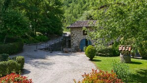 A stone building with a tiled roof, a gravel path leading to it, and a stone staircase. - Holiday House with Pool & Large Garden Overlooking Lake near Tuscany (Lisciano Niccone)