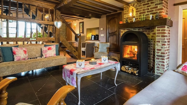 A cozy living room with a fireplace, wooden beams, and a staircase. - Scenic Retreat in Gimnee (Doische)