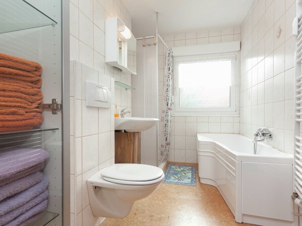Un baño pequeño con inodoro, lavamanos y bañera.