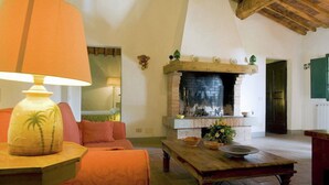 A cozy living room with a fireplace, a table with a bowl, and a lamp with a palm tree design. - Peaceful Apartment, Ghizzano (Peccioli)
