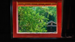A window with a view of lush green trees and a traditional building structure. - Peaceful Apartment, Ghizzano (Peccioli)