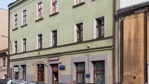 Monikerroksinen rakennus, jonka julkisivu on vihreä, siinä on useita ikkunoita ja kyltti, josta ilmenee, että siellä toimii WALZKITORBY.PL -niminen yritys.