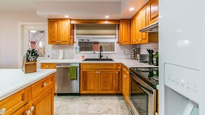 A modern kitchen with wooden cabinets, a stainless steel sink, and a built-in oven.