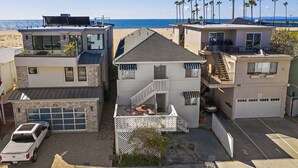 Um imóvel à beira-mar com arquitetura moderna, incluindo um edifício de dois andares com varanda e garagem.
