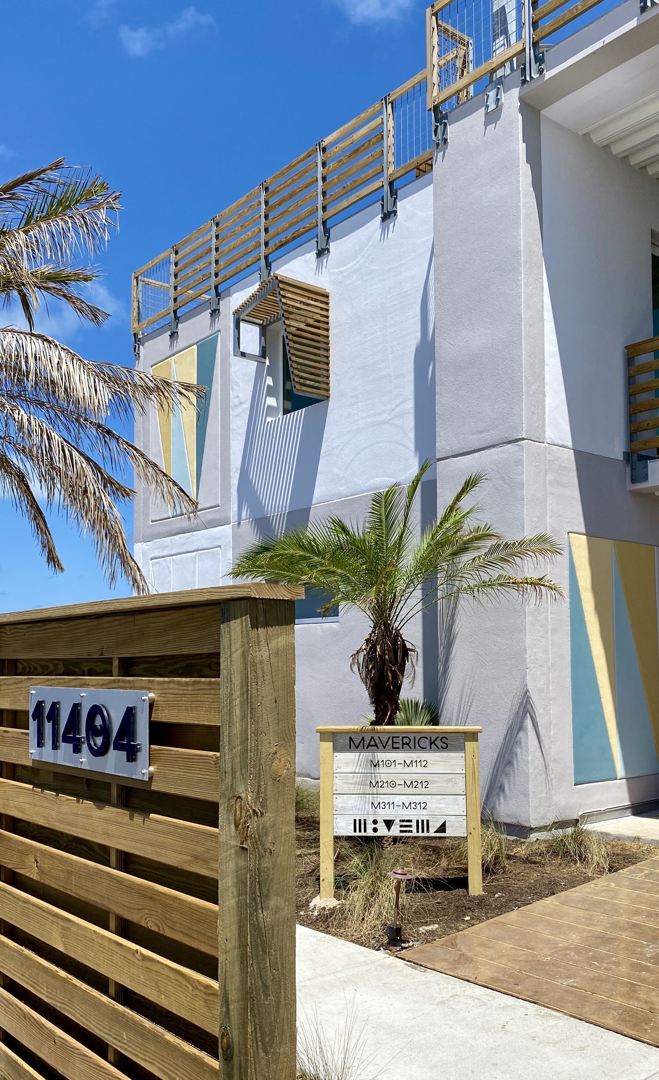A building with a sign indicating 'Mavericks' and a wooden gate with the number '11404'.