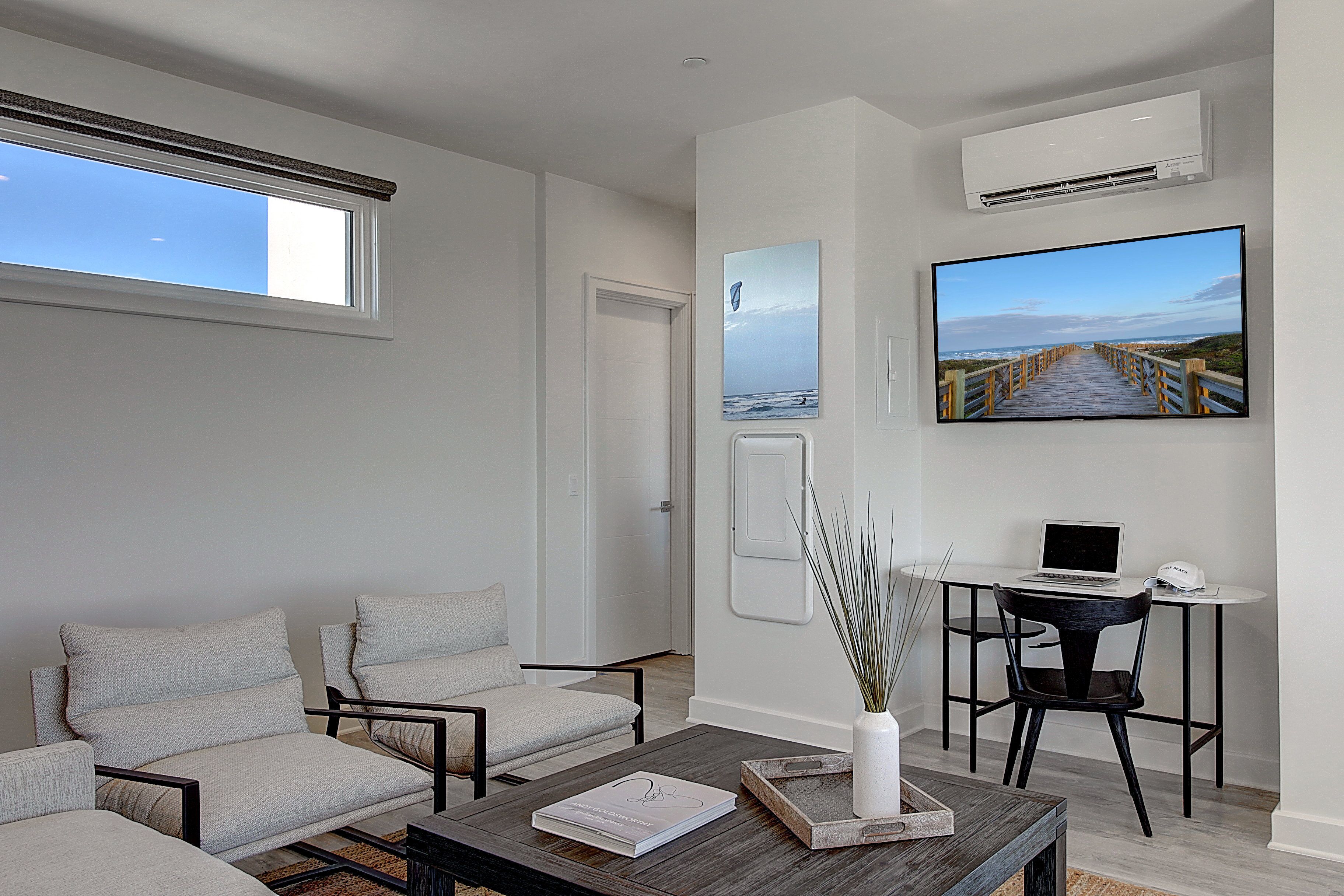 A modern living room with a sofa, coffee table, and a TV mounted on the wall.